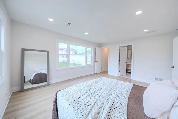 a spacious bedroom with a large bed and a window