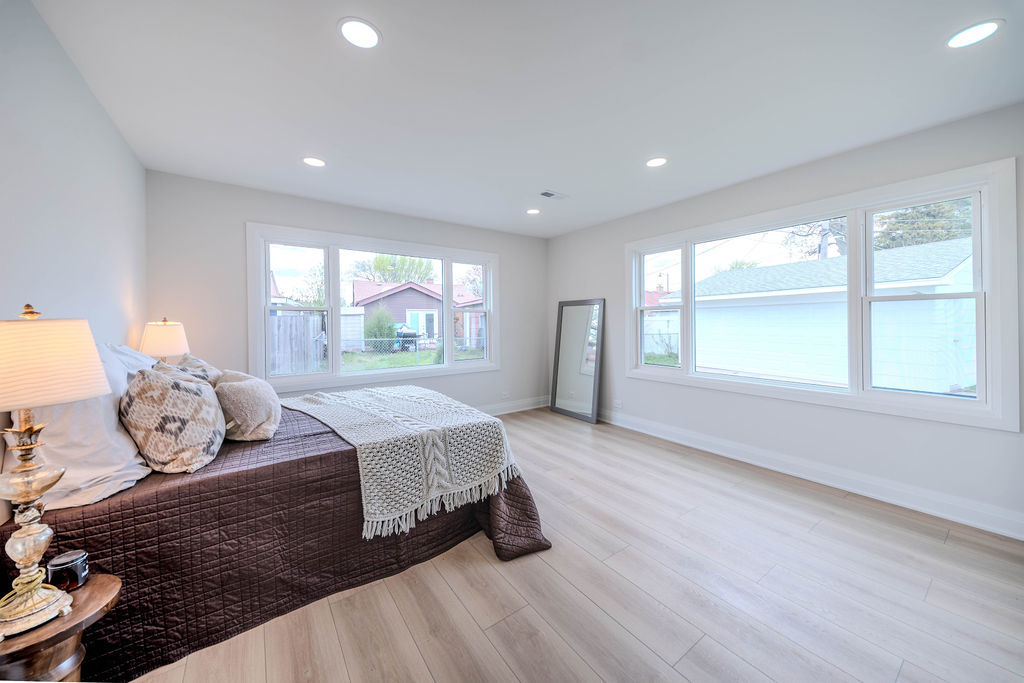 6964 West Cleveland Street Niles, IL 60714 - Photo 13 of 25 a spacious bedroom with a bed and wooden floor