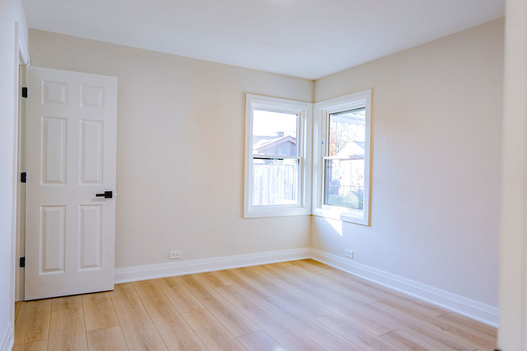 6964 West Cleveland Street Niles, IL 60714 - Photo 20 of 25 an empty room with wooden floor and windows