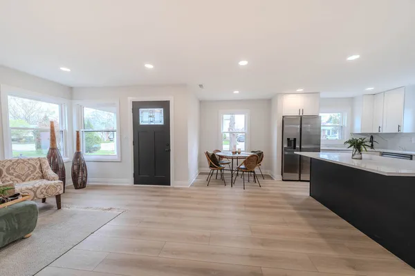 a living room with furniture and a dining table with kitchen view