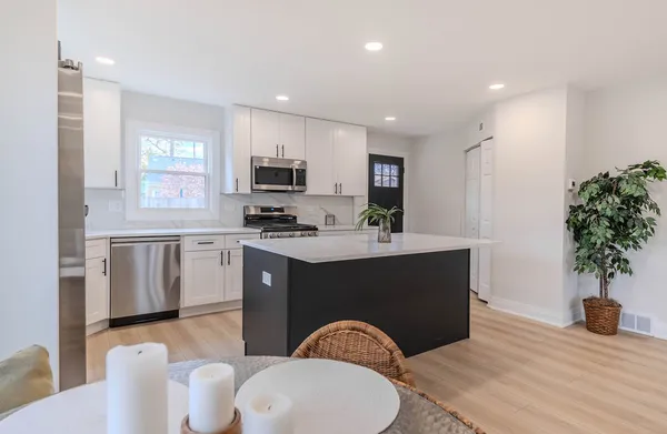 a kitchen with sink a microwave and cabinets