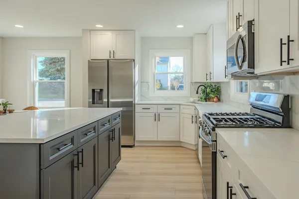 a kitchen with granite countertop a sink stove and refrigerator