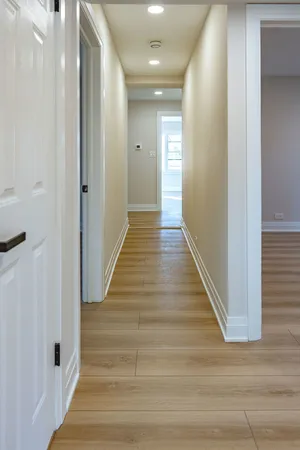 a view of a hallway with wooden floor and staircase