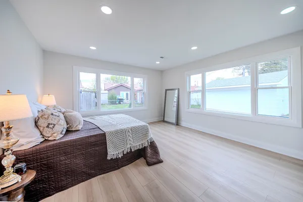 a spacious bedroom with a bed and wooden floor