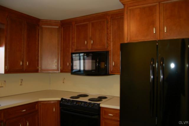 853 Cold Spring Road, Unit 6 Allentown, PA 18103 - Photo 10 of 23 a kitchen with a refrigerator and cabinets