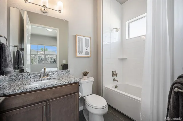 a bathroom with a granite countertop toilet sink and mirror