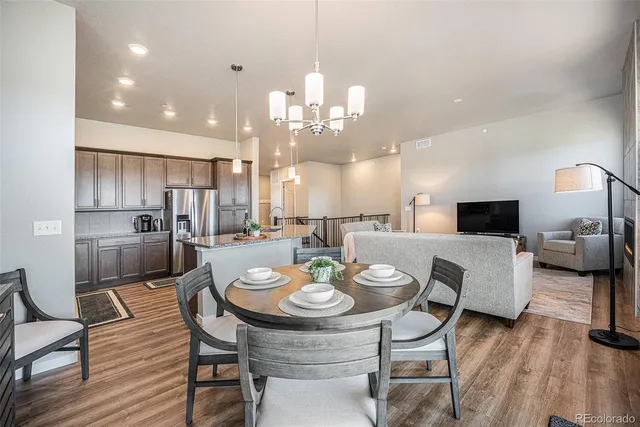 a kitchen with kitchen island granite countertop a refrigerator and a sink