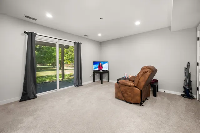 a living room with furniture a floor to ceiling window and a flat screen tv