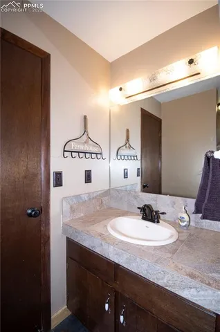 a bathroom with a granite countertop sink and a mirror