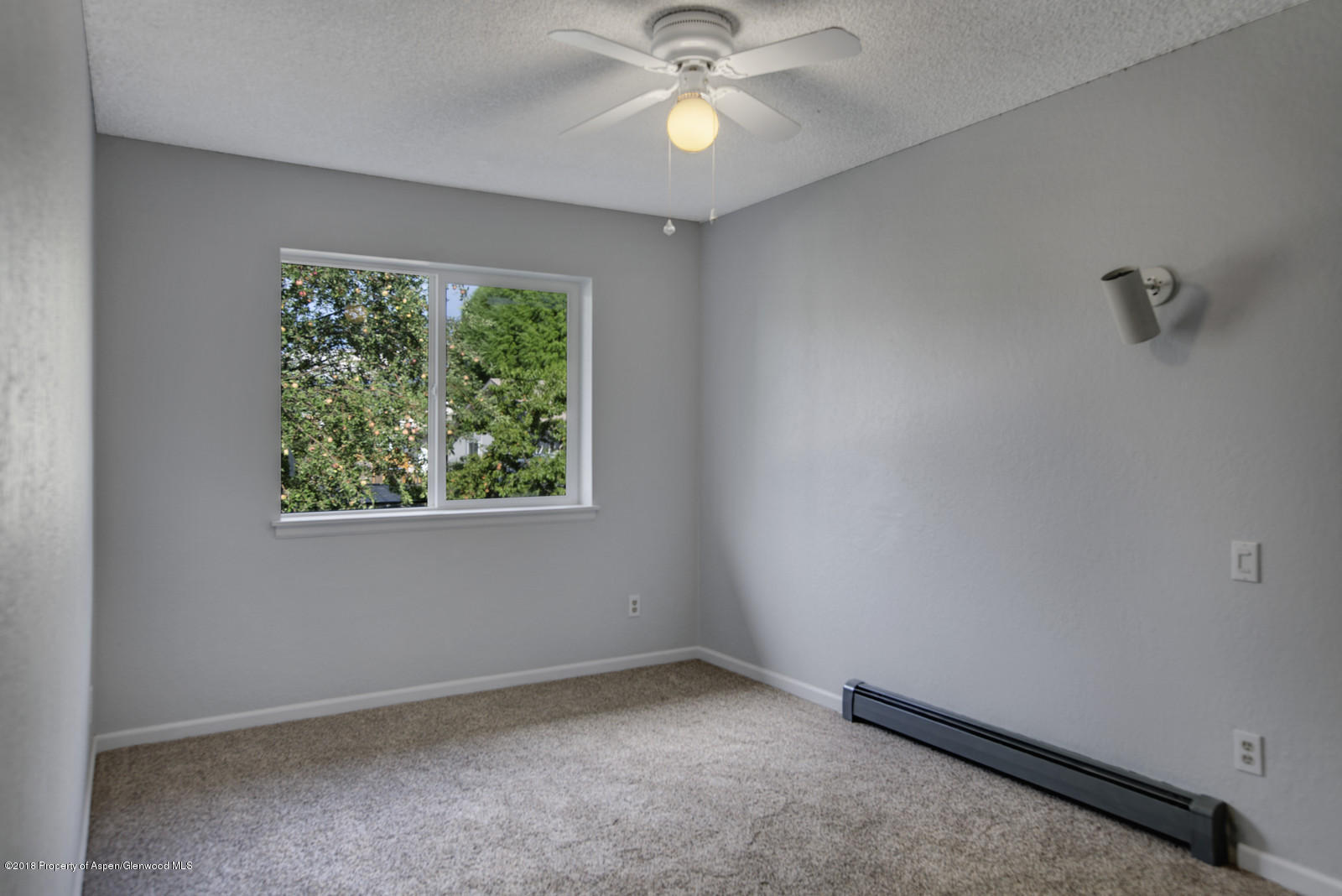 511 Hutton Avenue Rifle, CO 81650 - Photo 8 of 12 an empty room with a window and a fan