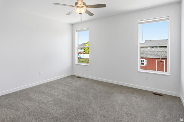 3636 West 910 South Syracuse, UT 84075 - Photo 12 of 70 Spacious room featuring neutral carpeting, white walls, and bright white trim