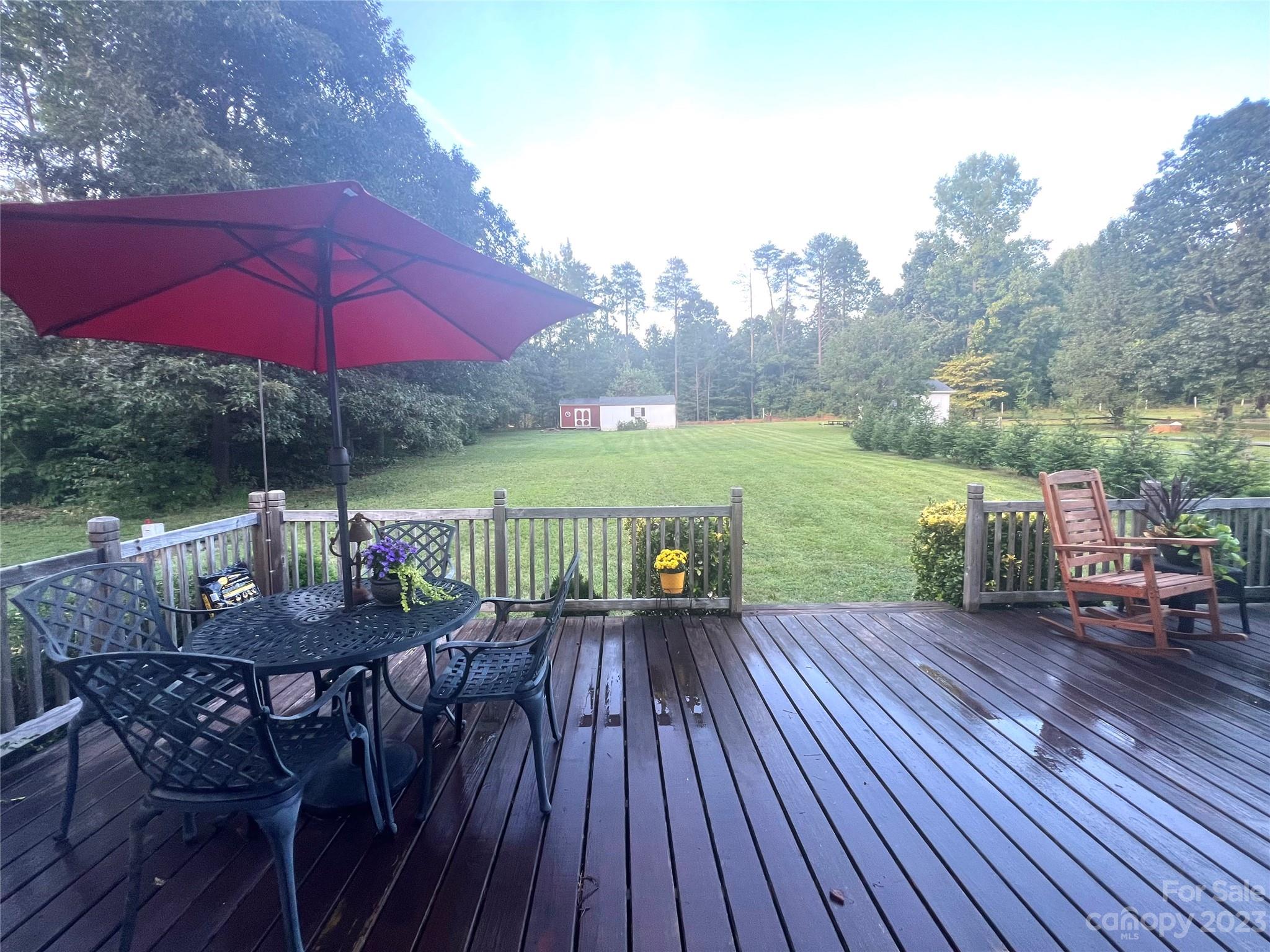 160 Hunters Pointe Drive Dallas, NC 28034 - Photo 26 of 31 a view of a roof deck with table and chairs under an umbrella with wooden floor