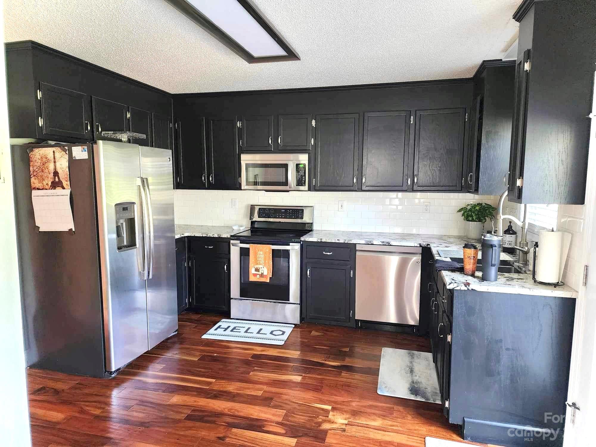 160 Hunters Pointe Drive Dallas, NC 28034 - Photo 5 of 31 a kitchen with stainless steel appliances granite countertop a refrigerator a stove a sink and a microwave
