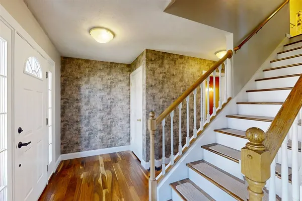 a view of hallway with stairs and wooden floor