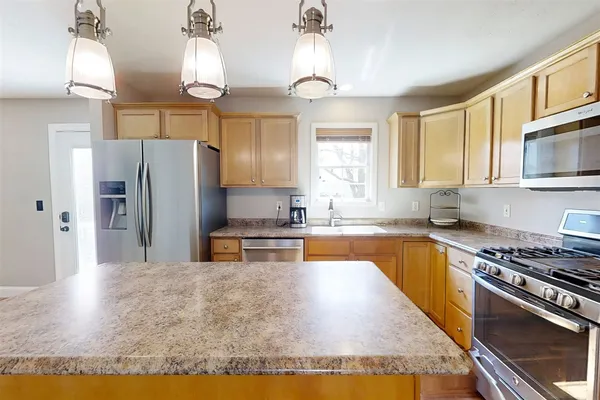 a kitchen with stainless steel appliances granite countertop a stove refrigerator and microwave