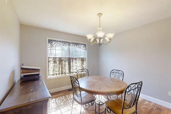 a view of a dining room with furniture a chandelier and wooden floor