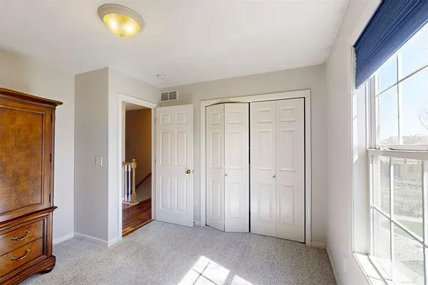 a view of an empty room with window and closet area
