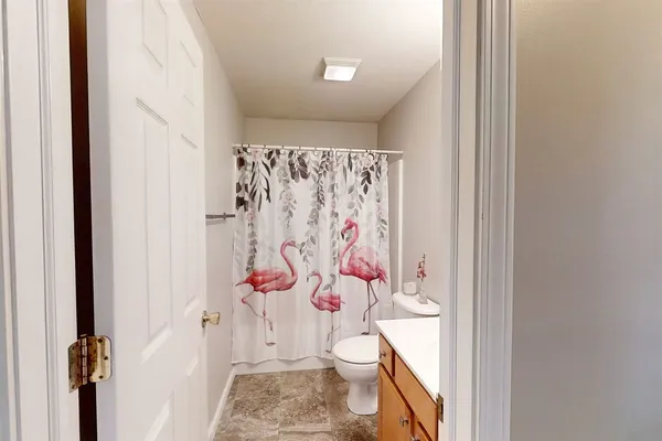 a bathroom with a toilet and a shower curtain