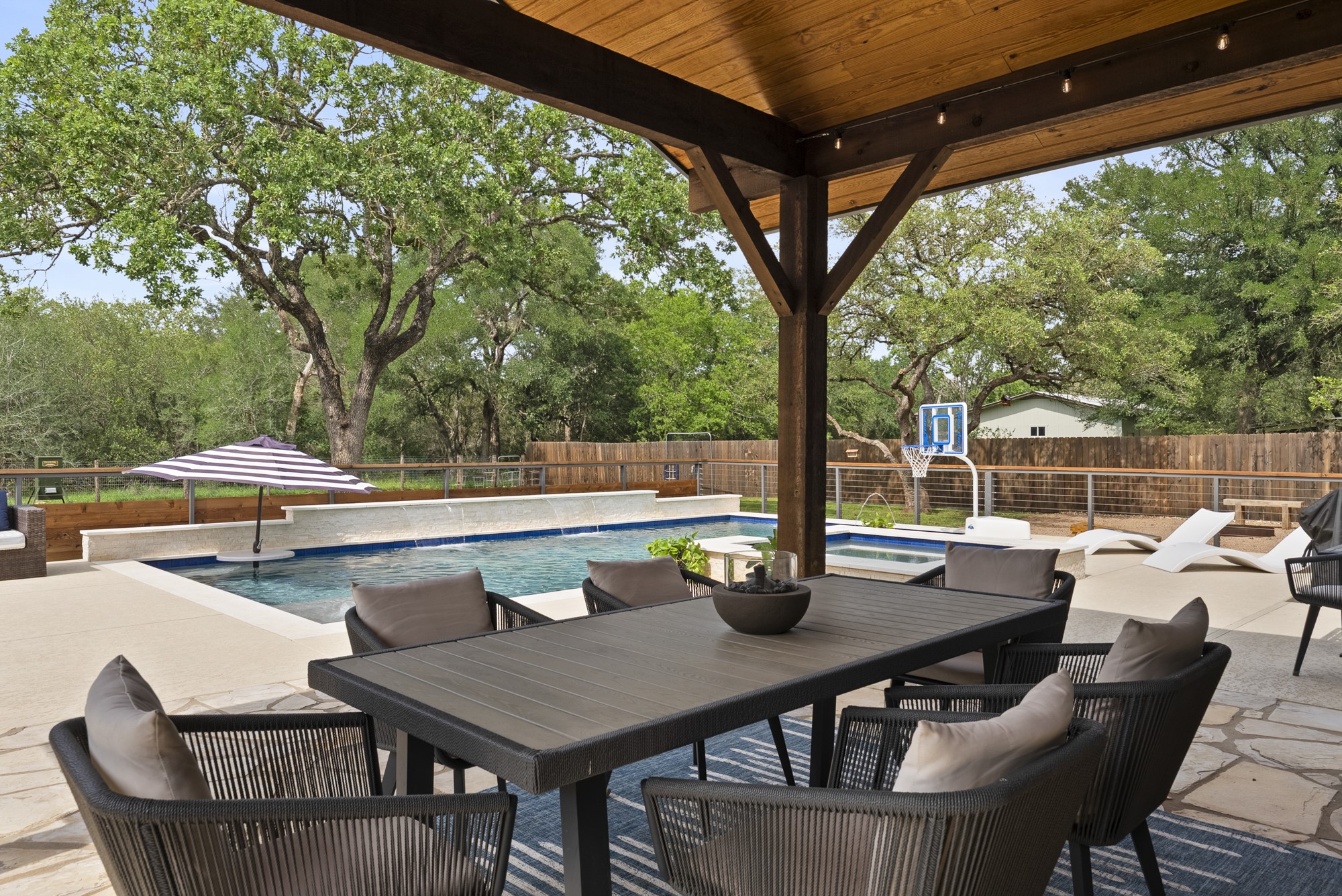 2802 Robin Road Manchaca, TX 78652 - Photo 18 of 40 Expansive outdoor living area featuring a covered patio with a wood-finish ceiling, a built-in swimming pool with a sun shelf, and surrounding concrete decking