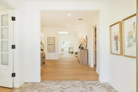 a view of an empty room with window and a livingroom