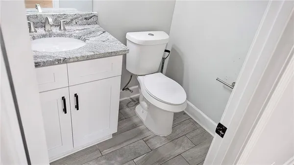 a bathroom with a granite countertop toilet and a sink