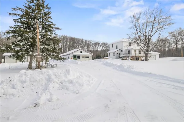 a view of residential houses with snow on the road