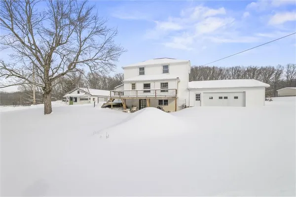a view of a house with a snow in the middle of a yard