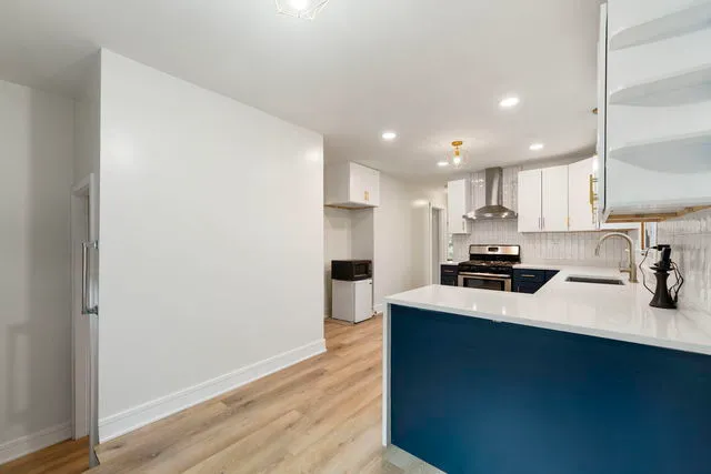 a kitchen with stainless steel appliances a sink refrigerator and cabinets