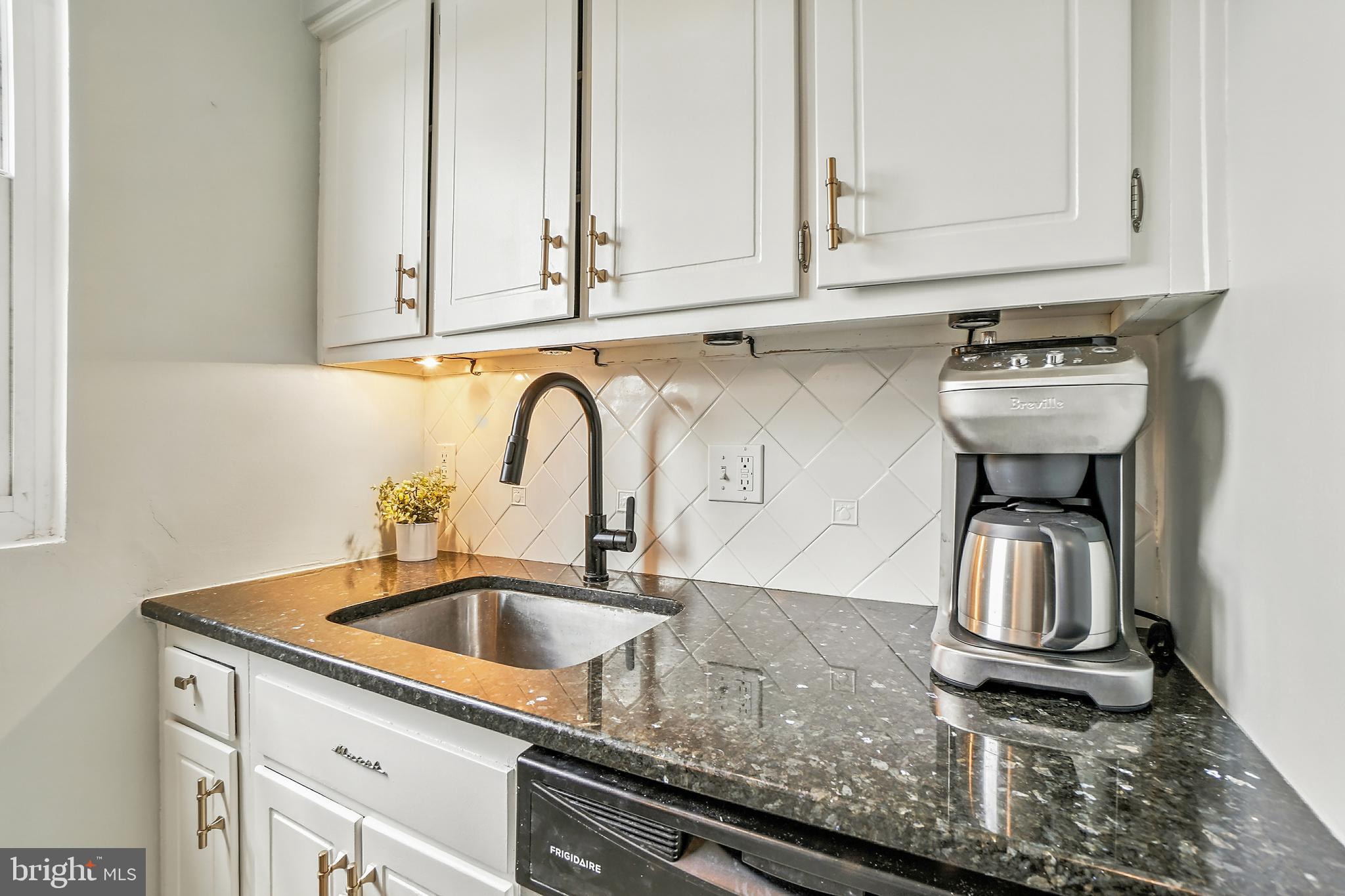 2030 North Vermont Street, Unit 301 Arlington, VA 22207 - Photo 10 of 32 a kitchen with kitchen island granite countertop a sink stainless steel appliances and cabinets