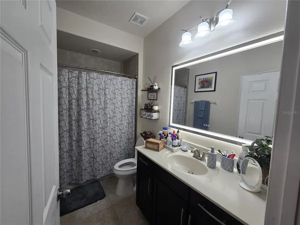 a spacious bathroom with a double vanity sink a mirror and a bathtub
