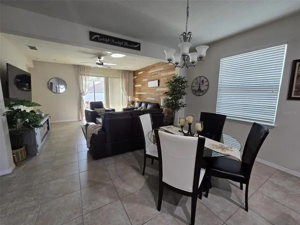 a kitchen with stainless steel appliances granite countertop a table chairs refrigerator and microwave