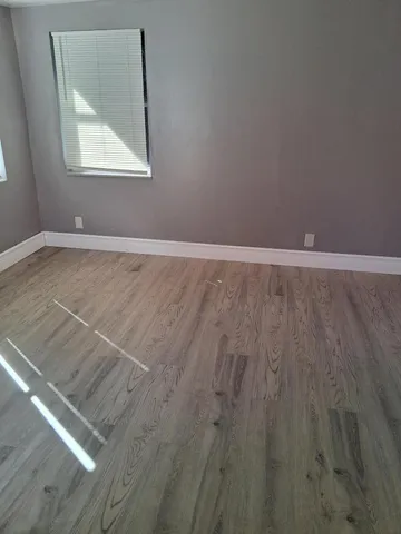 a view of a room with wooden floor and windows