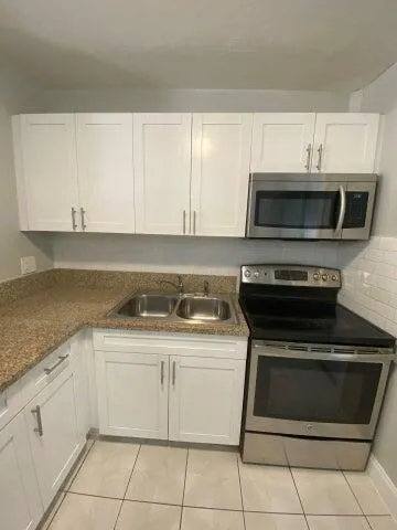 a kitchen with cabinets stainless steel appliances and a sink