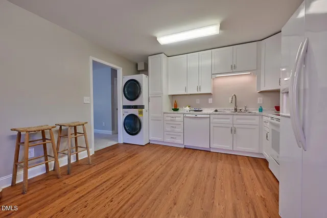 a kitchen with wooden floors and white cabinets