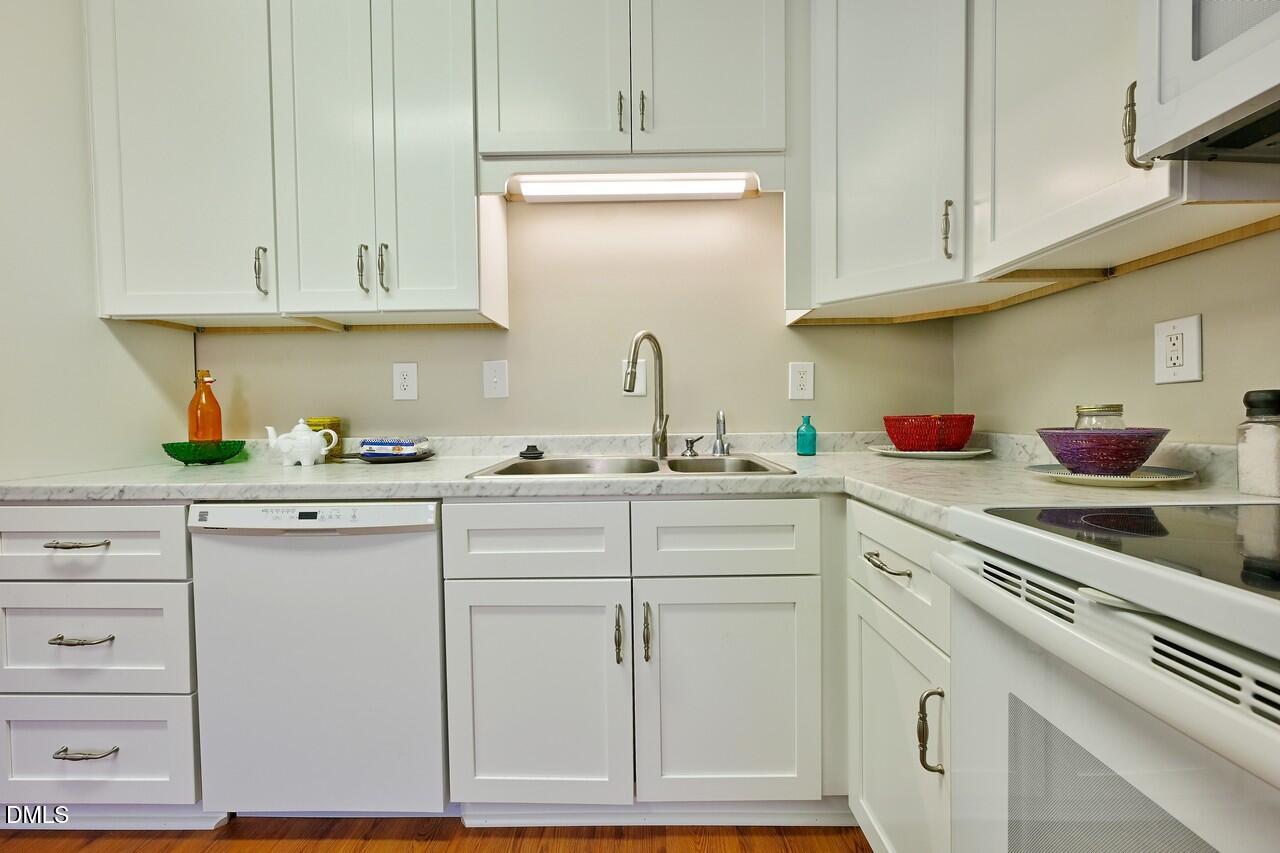 621 Martin Street Durham, NC 27704 - Photo 19 of 39 a kitchen with granite countertop white cabinets and white appliances