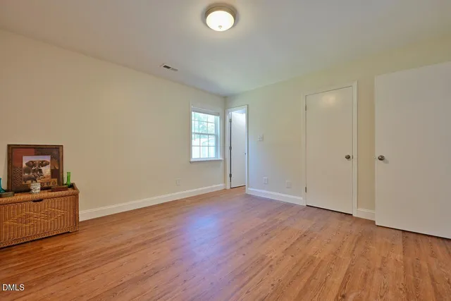 a view of an empty room with wooden floor