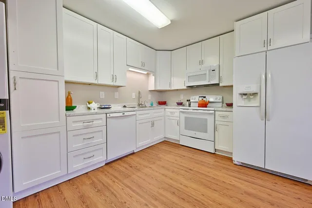a kitchen with white cabinets and white appliances