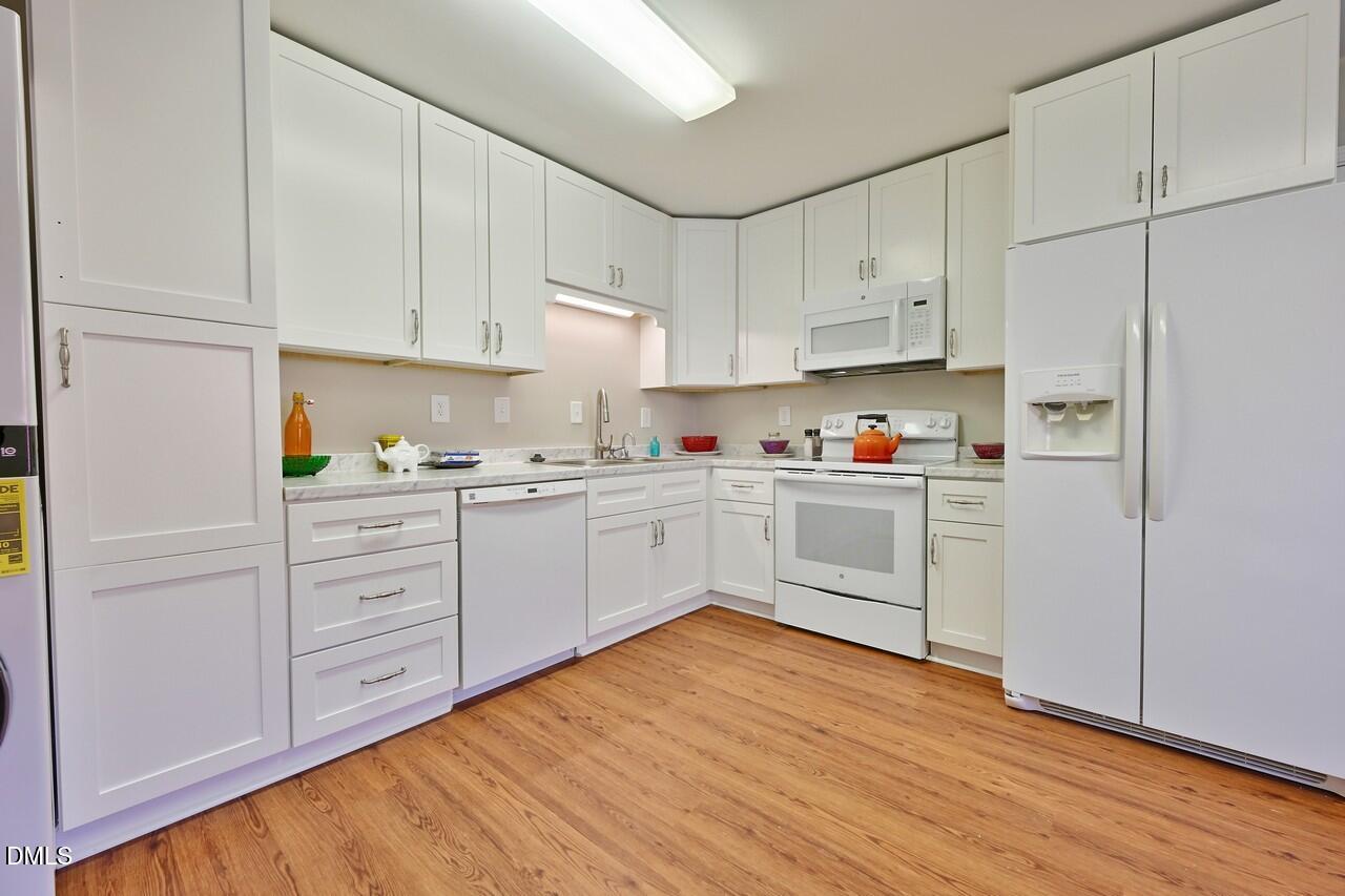 621 Martin Street Durham, NC 27704 - Photo 3 of 39 a kitchen with white cabinets and white appliances