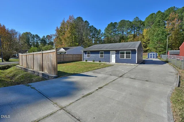 a view of a house with backyard and trees