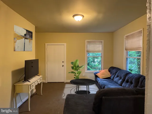 a living room with furniture a window and a flat screen tv
