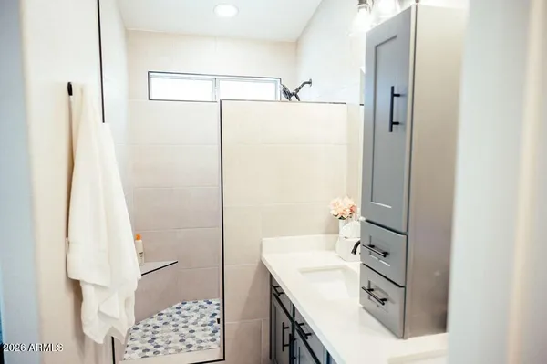 a bathroom with a shower sink and mirror