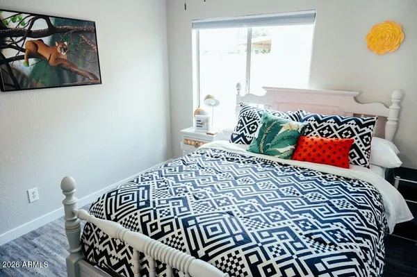 a bedroom with a bed and a painting on the wall