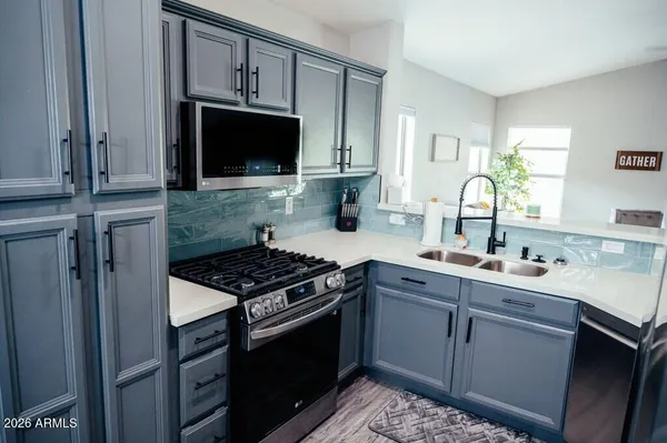 a kitchen with stainless steel appliances a sink stove and cabinets