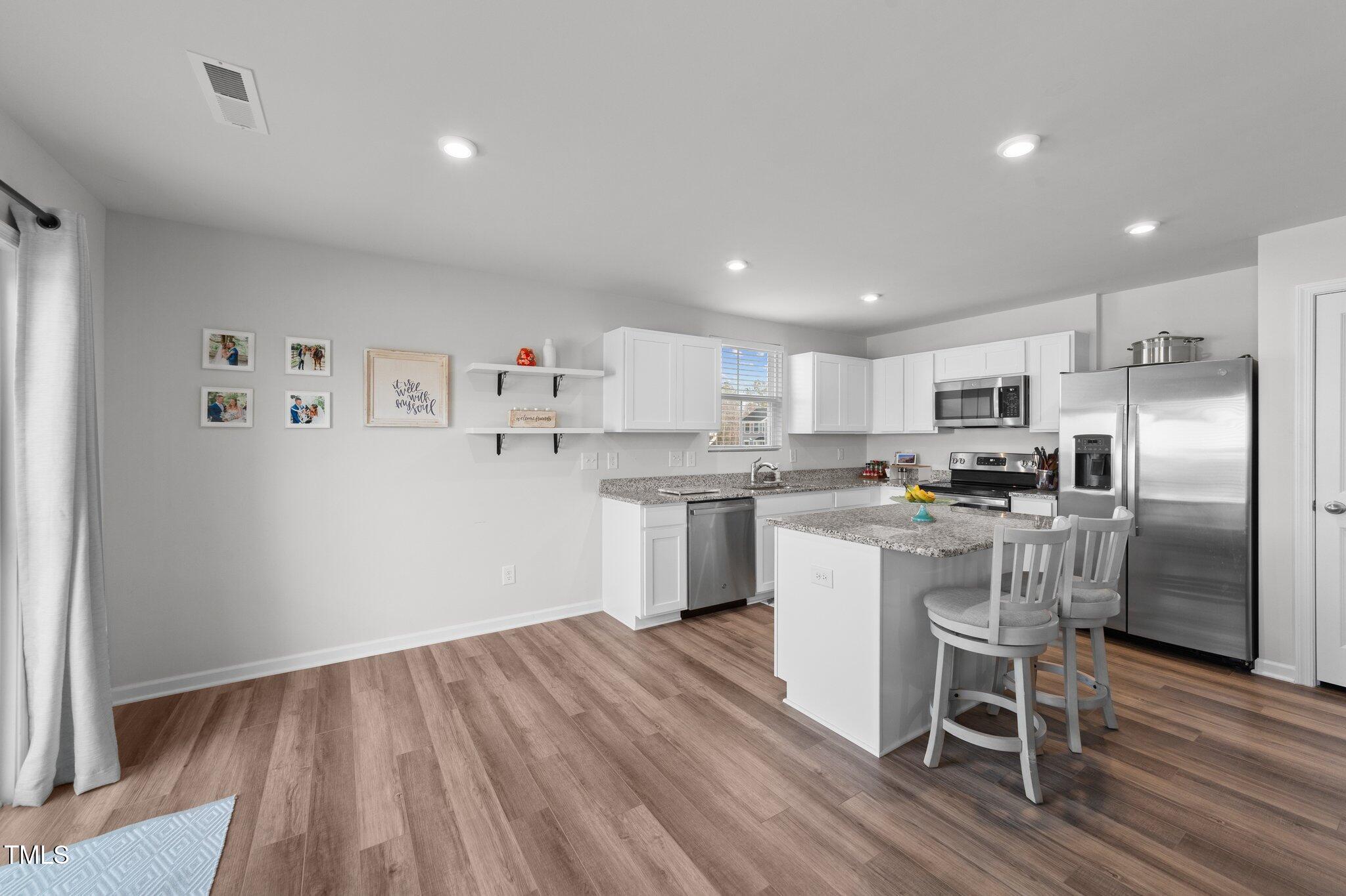 45 Florentine Court Angier, NC 27501 - Photo 16 of 27 a kitchen with a refrigerator and wooden floor