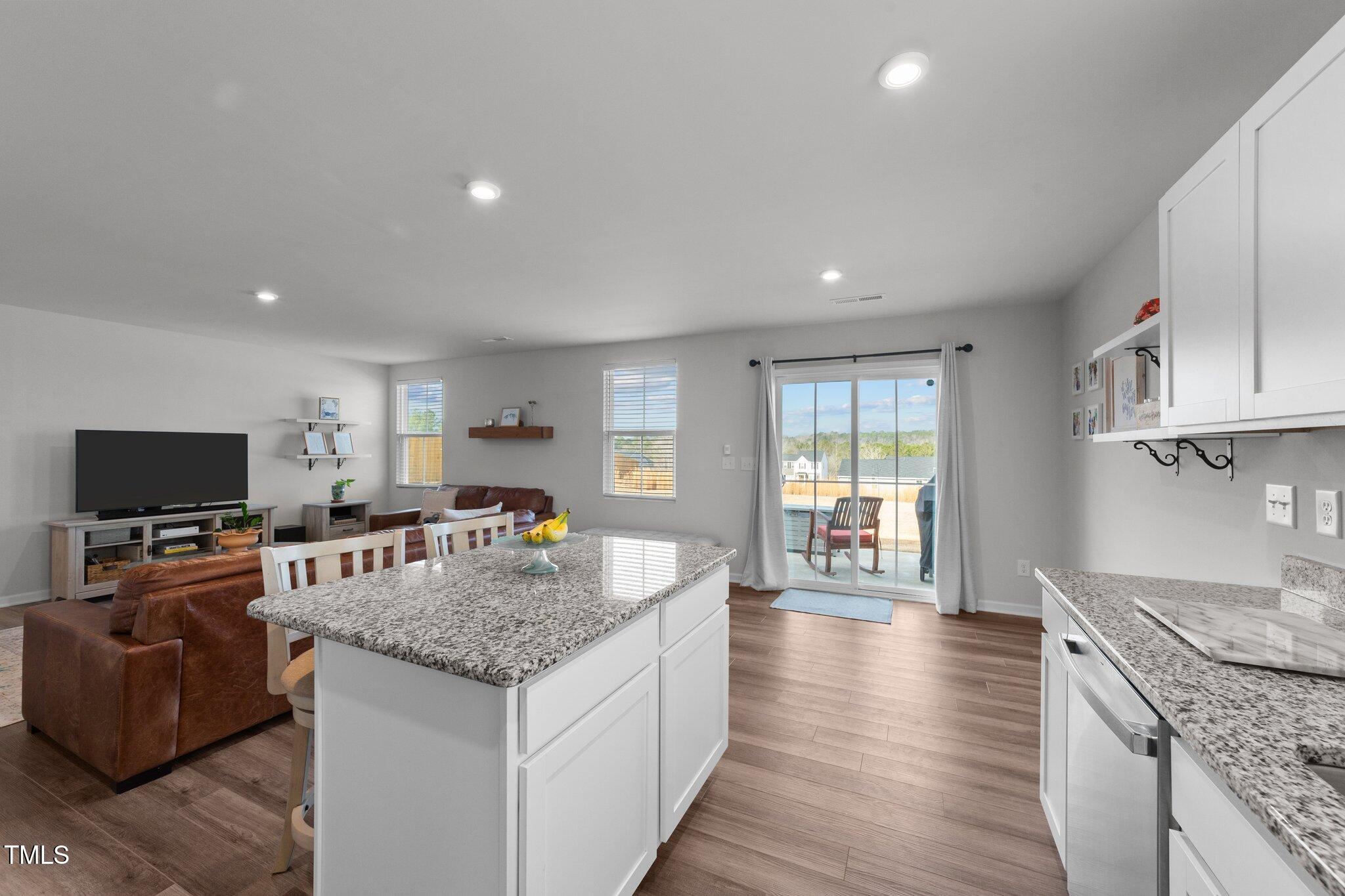 45 Florentine Court Angier, NC 27501 - Photo 18 of 27 a kitchen with granite countertop kitchen island stainless steel appliances a table and a living room