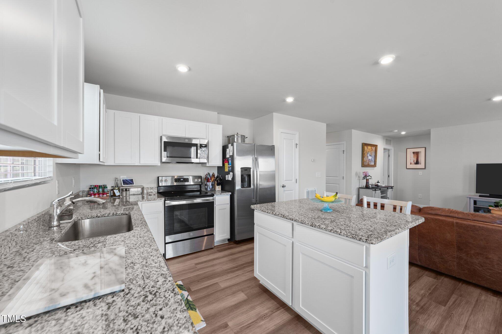 45 Florentine Court Angier, NC 27501 - Photo 19 of 27 a kitchen with stainless steel appliances granite countertop a sink stove and refrigerator