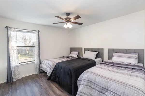 a bedroom with two large bed and a window
