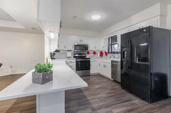 a kitchen with kitchen island white cabinets and stainless steel appliances