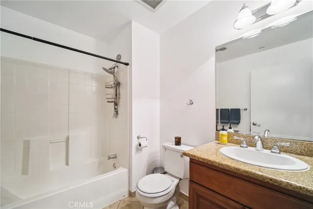 a bathroom with a granite countertop sink toilet a shower and a mirror