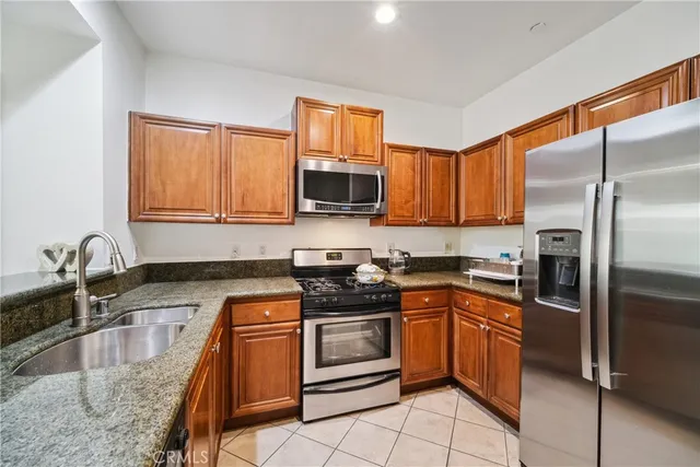 a kitchen with stainless steel appliances granite countertop a stove top oven a sink and dishwasher